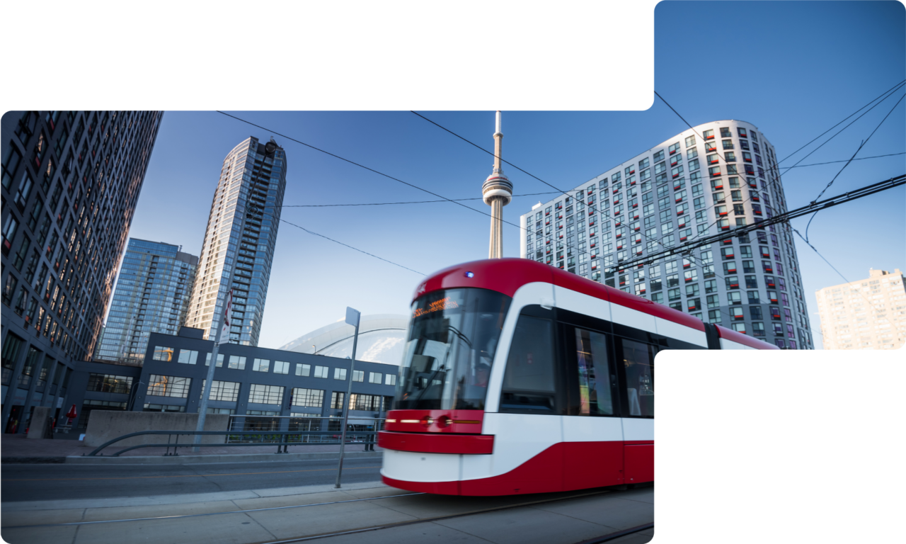 Photography of downtown Toronto with a train in the foreground and the CN Tower and office buildings in the background.